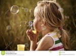 cute-girl-blowing-bubbles-field-20379489.jpg
