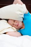3864962-young-woman-covering-ears-with-pillow-because-of-noise.jpg