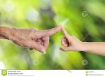 senior-s-hand-touching-child-s-hand-old-woman-green-background-34594860.jpg
